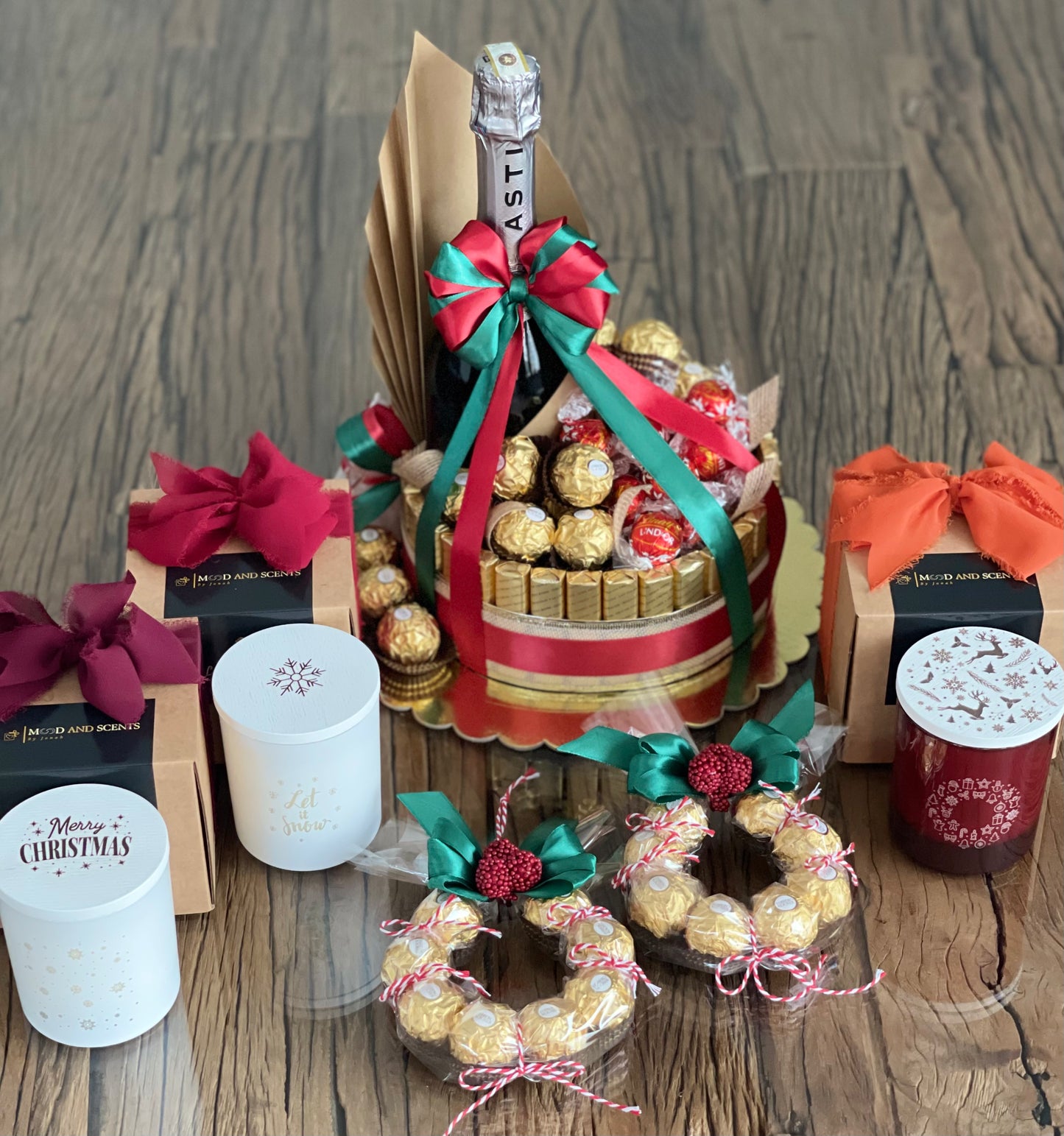 Wine and chocolate (ferrero, lindt and merci) arrangement. With Christmas ribbon for gift giving or as table centerpiece. Christmas gift ideas: soy candles, rapeseed and coconut candles with gify box and Christmas wreath. Mood and Scents!