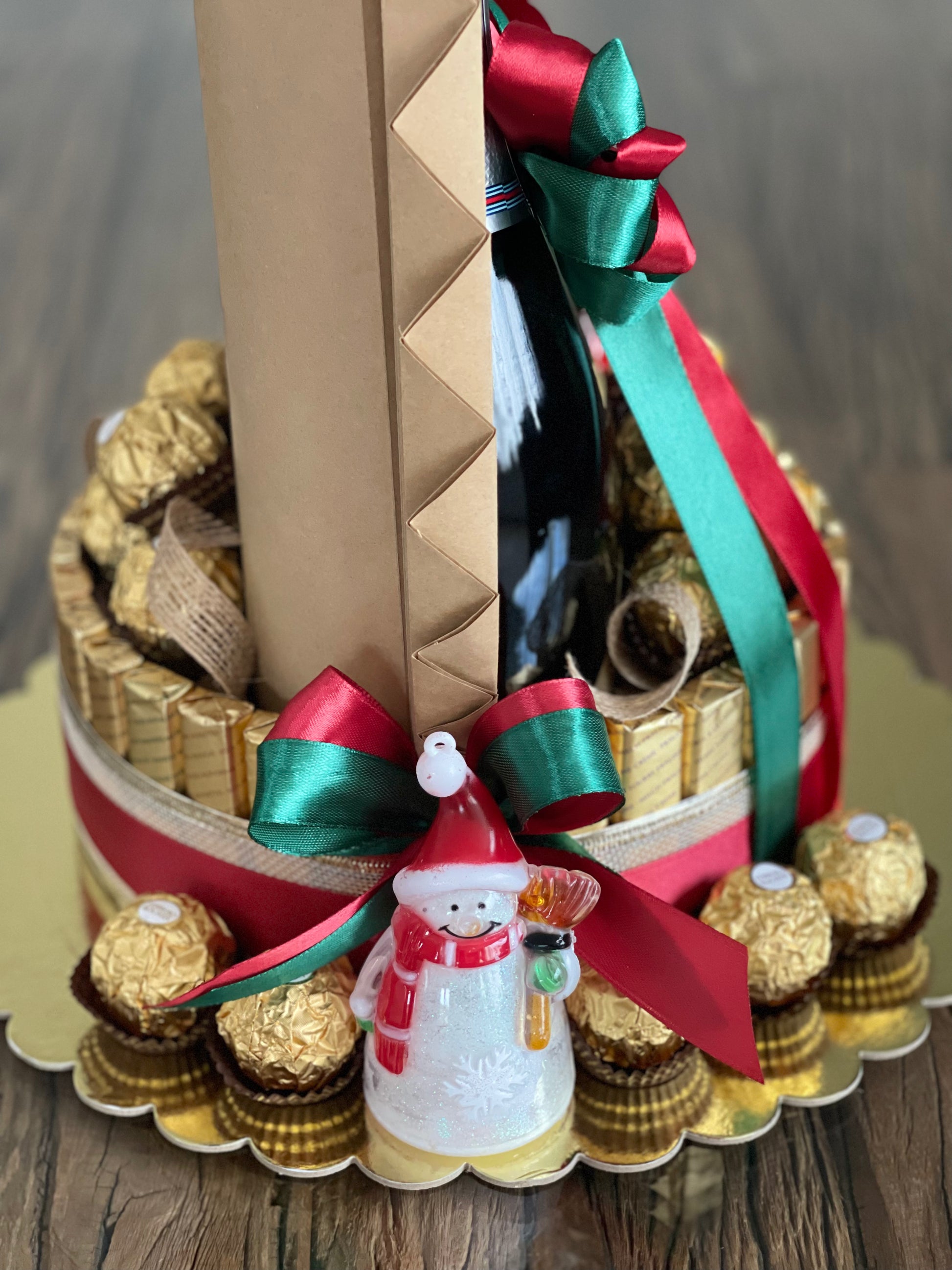 Wine and chocolate (ferrero, lindt and merci) arrangement. With Christmas ribbon for gift giving or as table centerpiece. Santaman close up view photo. Mood and Scents! 