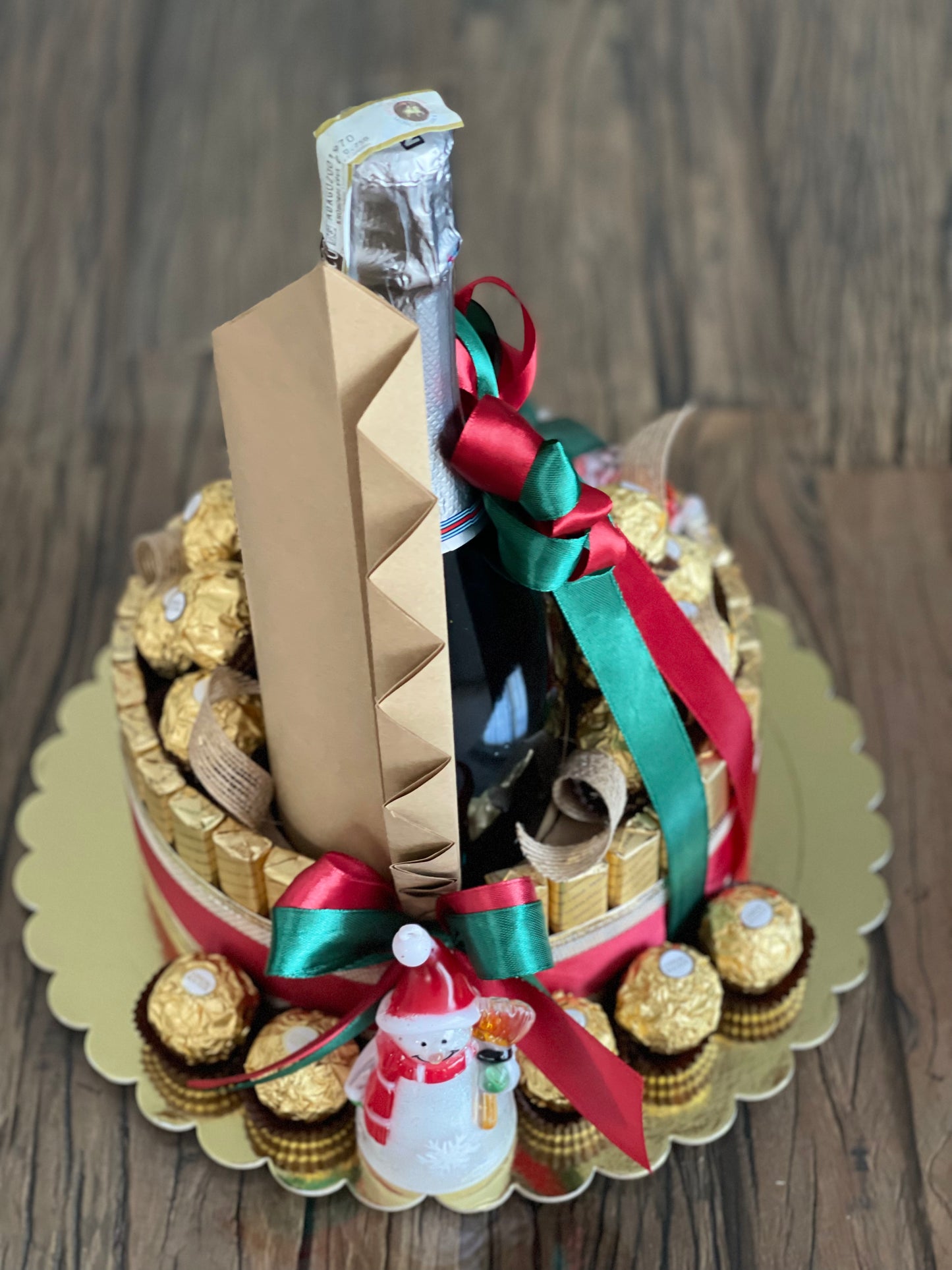 Wine and chocolate (ferrero, lindt and merci) arrangement. With Christmas ribbon for gift giving or as table centerpiece. Back view photo. Mood and Scents! 