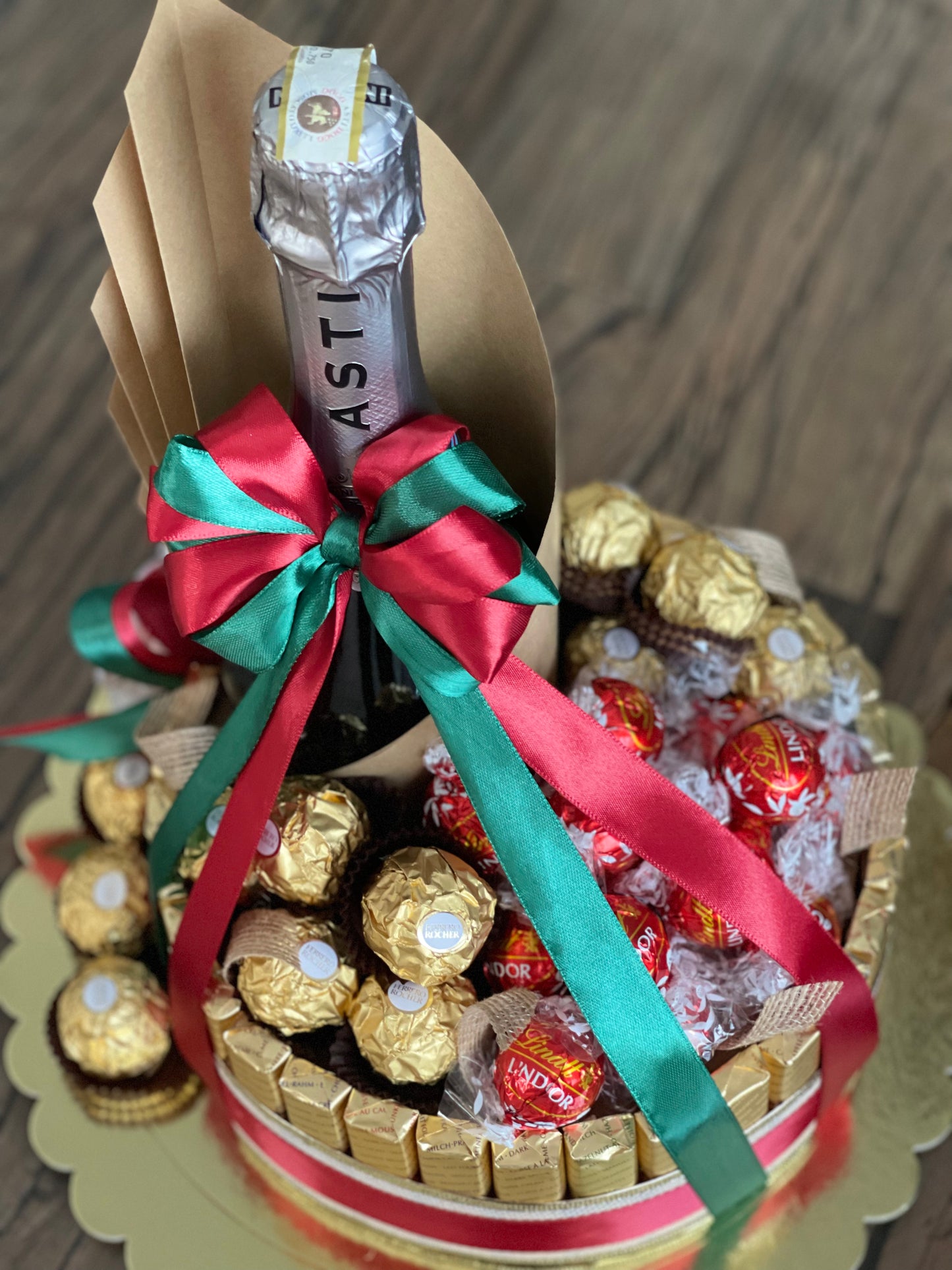 Wine and chocolate (ferrero, lindt and merci) arrangement. With Christmas ribbon for gift giving or as table centerpiece. Close up view photo. Mood and Scents! 